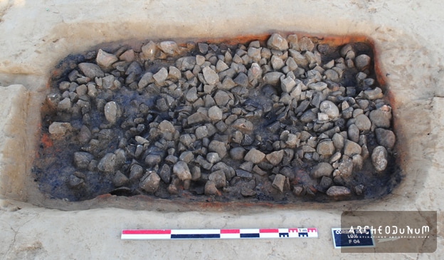 Fig. 5 : La fosse d’un foyer, avec les bords rougis par le feu et la couche charbonneuse qui apparaît sous les galets