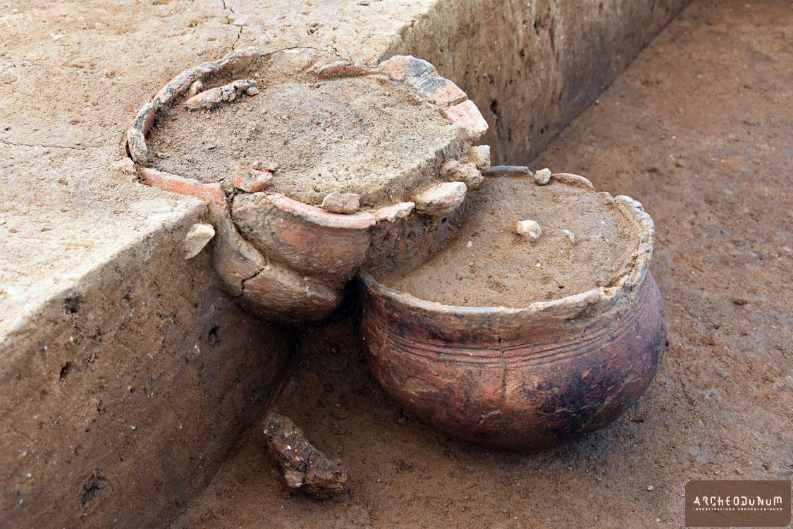 Détail de deux vases déposés sur deux niveaux au sein de la même sépulture. Le récipient à la base comporte un décor de quatre cannelures 