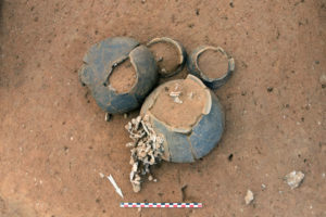 Vase ossuaire et concentration d’ossements calcinés (en bas), vase biconique (à gauche) et gobelets (en haut)