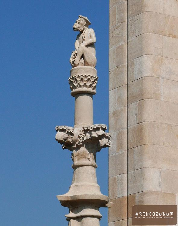 Ainay-le-Vieil - Au sommet d’une lucarne : sculpture de singe enchaîné.